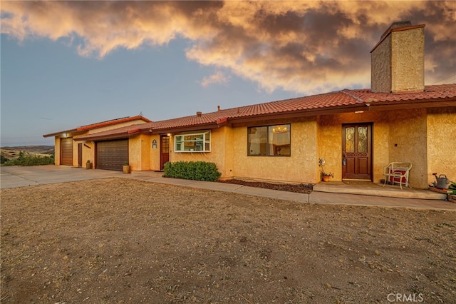 14320 Kiptree Dr, Lake Hughes, CA 93532 - view of front of house with driveway, a garage, a tiled roof, and stucco siding