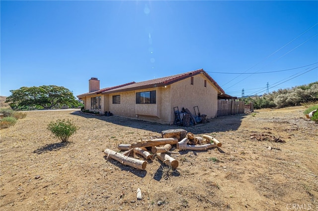 14320 Kiptree Dr, Lake Hughes, CA 93532 - back of house featuring a chimney and stucco siding