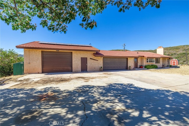 14320 Kiptree Dr, Lake Hughes, CA 93532 - ranch-style home featuring a tile roof, an attached garage, stucco siding, solar panels, and driveway