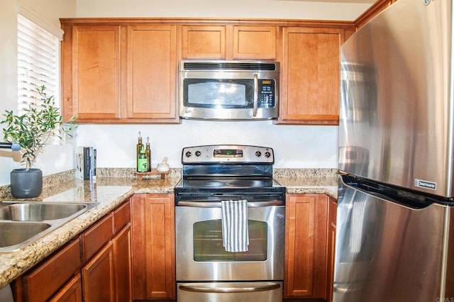 12191 Cuyamaca College Dr E Unit 703, San Diego, CA 92019 - kitchen with appliances with stainless steel finishes, brown cabinets, and light stone counters