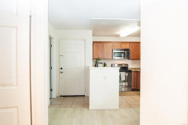 12191 Cuyamaca College Dr E Unit 703, San Diego, CA 92019 - kitchen featuring appliances with stainless steel finishes, brown cabinets, light countertops, and light wood-style flooring