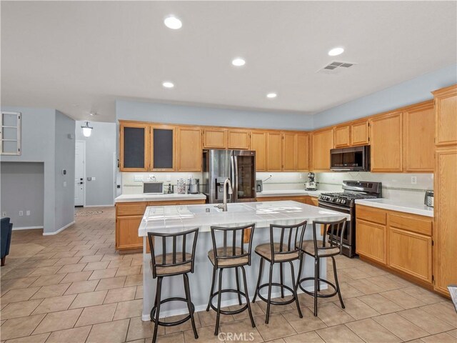 28323 Roman Ct, Saugus, CA 91350 - kitchen featuring appliances with stainless steel finishes, an island with sink, light countertops, a breakfast bar area, and recessed lighting