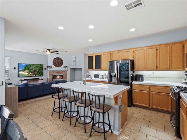 28323 Roman Ct, Saugus, CA 91350 - kitchen with black range with gas stovetop, refrigerator with ice dispenser, tile counters, light tile patterned floors, and a ceiling fan