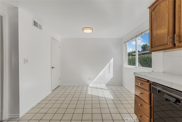 6304 Tamarind St, Oak Park, CA 91377 - kitchen with dishwasher, tile countertops, and brown cabinetry