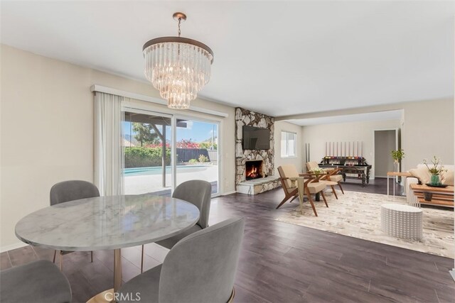 6304 Tamarind St, Oak Park, CA 91377 - dining space with a stone fireplace, wood finished floors, and a chandelier