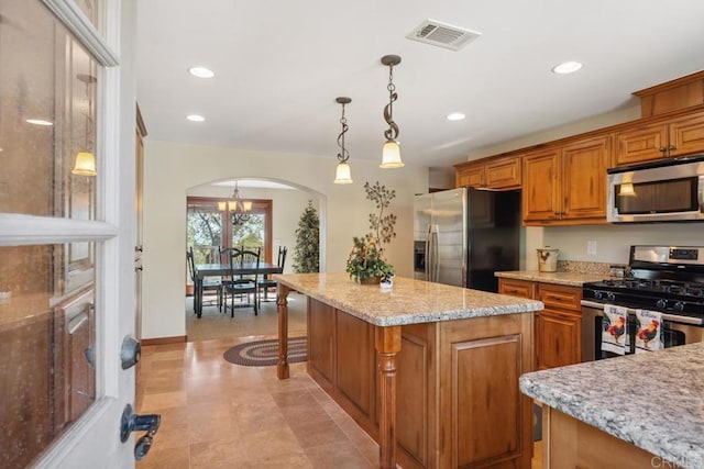 1480 Round Potrero Rd, Potrero, CA 91963 - kitchen with stainless steel appliances, arched walkways, brown cabinetry, a center island, and decorative light fixtures
