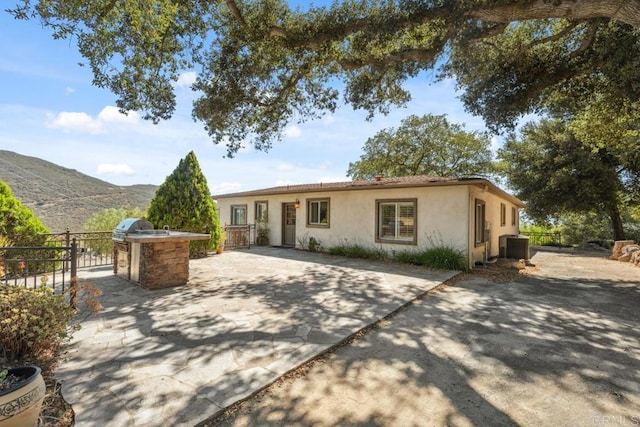 1480 Round Potrero Rd, Potrero, CA 91963 - view of front of property with stucco siding, an outdoor kitchen, a mountain view, and a patio