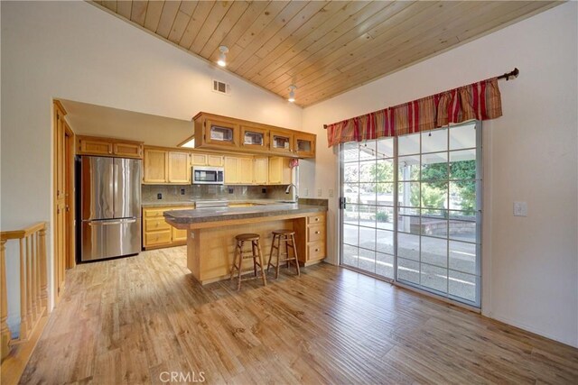 355 Via Vicente, Nipomo, CA 93444 - kitchen featuring stainless steel appliances, a peninsula, high vaulted ceiling, light wood-type flooring, and glass insert cabinets