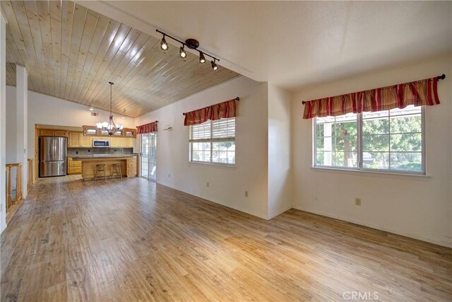 355 Via Vicente, Nipomo, CA 93444 - unfurnished living room with a chandelier, plenty of natural light, light wood-style flooring, and vaulted ceiling