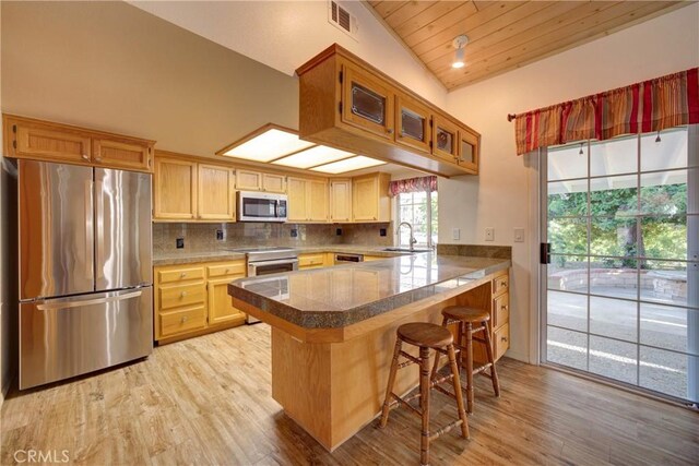 355 Via Vicente, Nipomo, CA 93444 - kitchen featuring stainless steel appliances, a peninsula, light wood-style flooring, tile countertops, and a kitchen bar