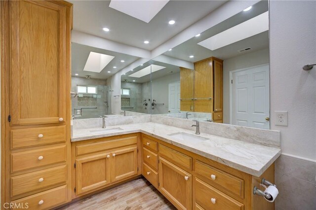 355 Via Vicente, Nipomo, CA 93444 - bathroom featuring a skylight, double vanity, a stall shower, wood finished floors, and recessed lighting