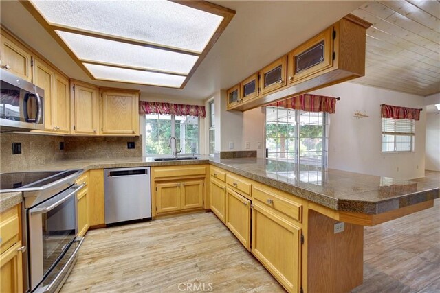 355 Via Vicente, Nipomo, CA 93444 - kitchen with stainless steel appliances, a peninsula, tile countertops, a breakfast bar area, and glass insert cabinets