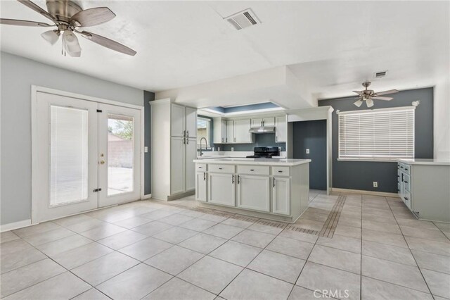 44740 Jefferson Ct, Lancaster, CA 93535 - kitchen featuring under cabinet range hood, french doors, range, ceiling fan, and light countertops