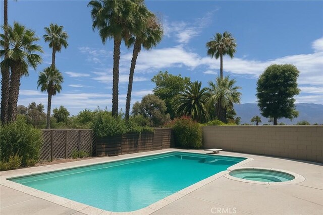 41150 Nona Ct, Hemet, CA 92544 - view of swimming pool with a diving board, a mountain view, and a pool with connected hot tub