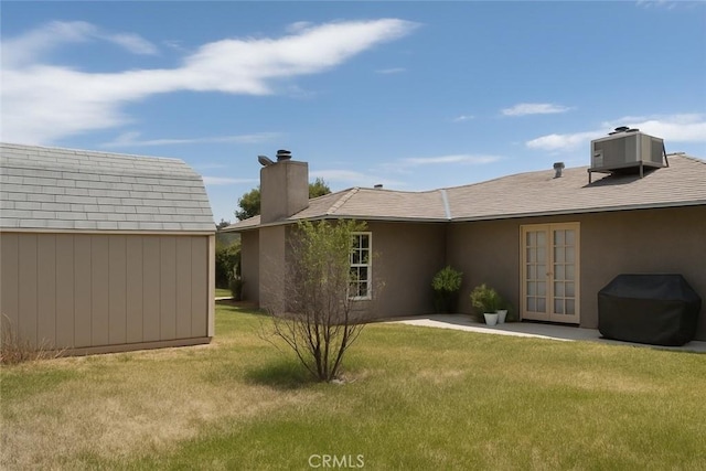 41150 Nona Ct, Hemet, CA 92544 - rear view of house with french doors, a yard, a chimney, and a storage unit