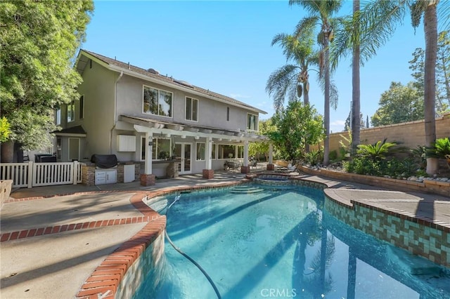 24622 Cresta Ct, Laguna Hills, CA 92653 - view of swimming pool featuring an outdoor kitchen, a fenced backyard, french doors, a patio, and a pool with connected hot tub