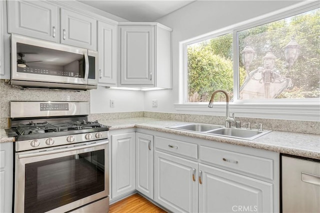 17787 Merridy St, Northridge, CA 91325 - kitchen featuring appliances with stainless steel finishes, white cabinetry, light countertops, and ceiling fan