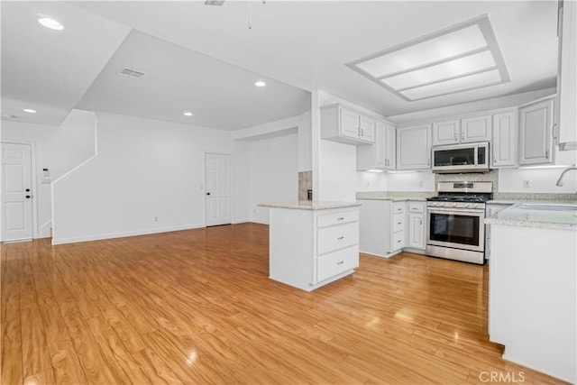 17787 Merridy St, Northridge, CA 91325 - kitchen featuring stainless steel gas range oven, light wood finished floors, open floor plan, light stone countertops, and recessed lighting