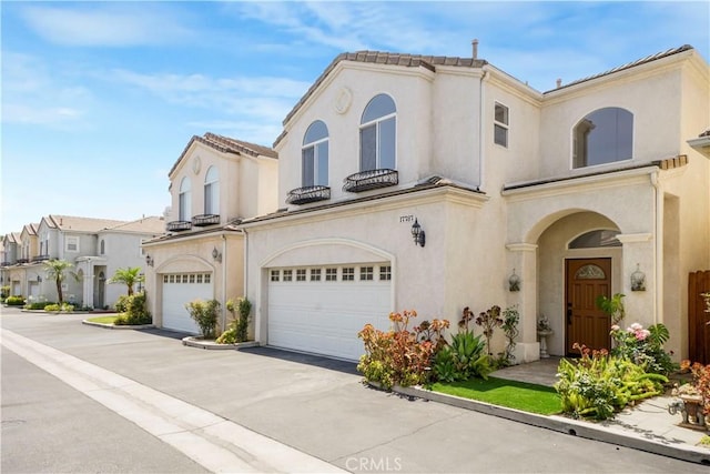 17787 Merridy St, Northridge, CA 91325 - mediterranean / spanish-style house featuring a garage, stucco siding, asphalt driveway, and a residential view