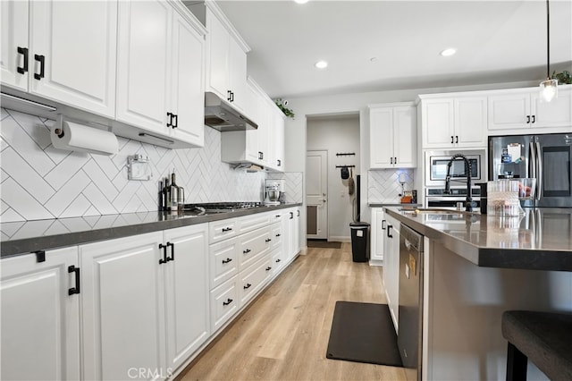 11715 Periwinkle Pl, Jurupa Valley, CA 91752 - kitchen with stainless steel appliances, under cabinet range hood, white cabinetry, tasteful backsplash, and recessed lighting