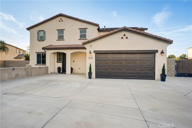 11715 Periwinkle Pl, Jurupa Valley, CA 91752 - mediterranean / spanish-style home featuring stucco siding, driveway, a tiled roof, and a garage