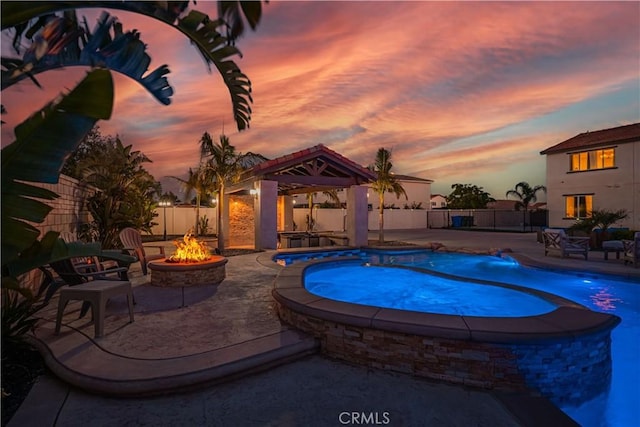 11715 Periwinkle Pl, Jurupa Valley, CA 91752 - pool at dusk with a gazebo, a fire pit, an in-ground hot tub, and a patio area