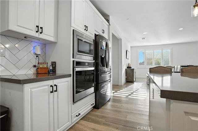 11715 Periwinkle Pl, Jurupa Valley, CA 91752 - kitchen featuring stainless steel appliances, dark countertops, backsplash, white cabinetry, and recessed lighting