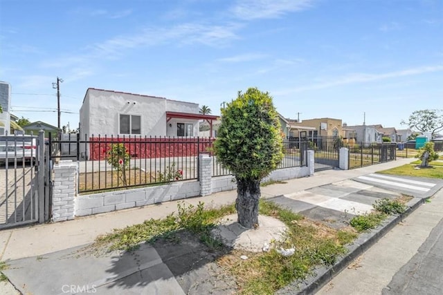 727 E 94th St, Los Angeles, CA 90002 - view of front of house with a gate, a fenced front yard, and stucco siding