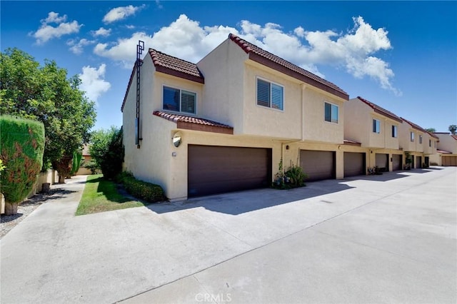 225 W Mission Rd Unit A, San Gabriel, CA 91776 - rear view of house featuring a tile roof, a garage, stucco siding, and driveway