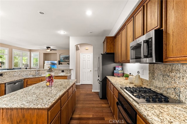 13014 Bermuda Ave, Chino, CA 91710 - kitchen with appliances with stainless steel finishes, brown cabinets, dark wood-style flooring, a kitchen island, and recessed lighting