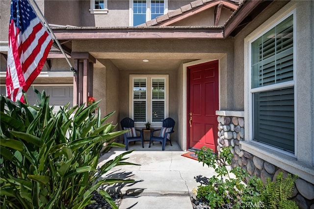 13014 Bermuda Ave, Chino, CA 91710 - property entrance featuring stucco siding, a porch, stone siding, and a garage