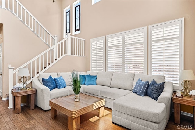 13014 Bermuda Ave, Chino, CA 91710 - living area featuring healthy amount of natural light, stairway, wood finished floors, and a towering ceiling