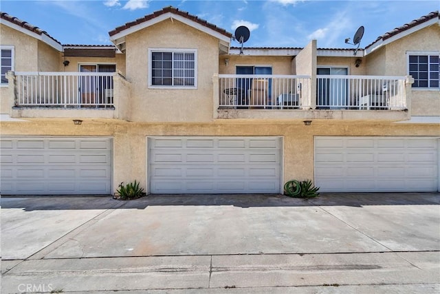 12012 Sproul St Unit 1/2, Norwalk, CA 90650 - view of front facade with stucco siding, a garage, and a tiled roof