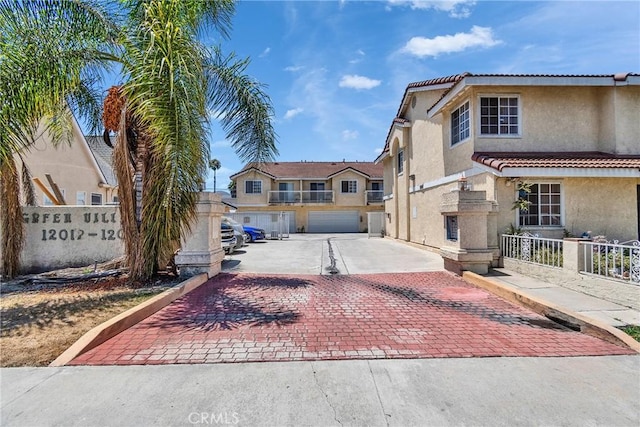12012 Sproul St Unit 1/2, Norwalk, CA 90650 - view of front of property with stucco siding, driveway, a tile roof, and a garage