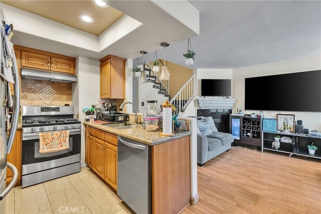 12012 Sproul St Unit 1/2, Norwalk, CA 90650 - kitchen featuring appliances with stainless steel finishes, open floor plan, under cabinet range hood, a peninsula, and backsplash