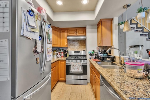 12012 Sproul St Unit 1/2, Norwalk, CA 90650 - kitchen with stainless steel appliances, under cabinet range hood, a tray ceiling, decorative backsplash, and light stone counters