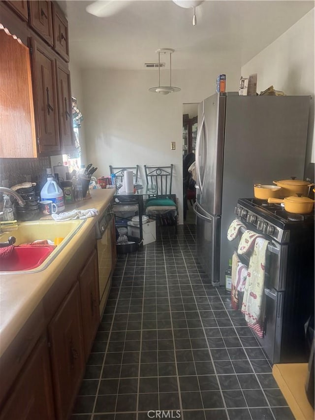 3500 S Norton Ave, Los Angeles, CA 90018 - kitchen with light countertops, freestanding refrigerator, dark tile patterned floors, and backsplash