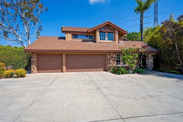 27681 Paseo Esteban, San Juan Capistrano, CA 92675 - view of front of house featuring stone siding, driveway, a tiled roof, and an attached garage