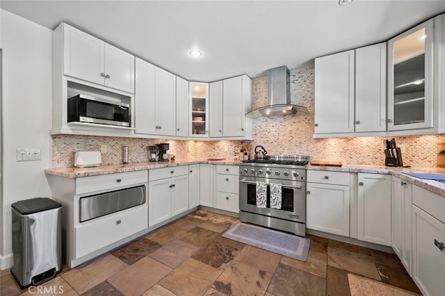 27681 Paseo Esteban, San Juan Capistrano, CA 92675 - kitchen with wall chimney exhaust hood, appliances with stainless steel finishes, a warming drawer, dark stone finish floors, and recessed lighting