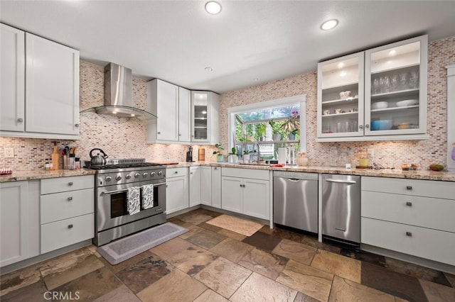 27681 Paseo Esteban, San Juan Capistrano, CA 92675 - kitchen with stainless steel appliances, wall chimney exhaust hood, decorative backsplash, stone tile flooring, and white cabinetry