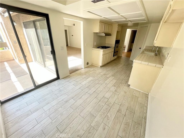 640 S Lake Ave Unit 306, Pasadena, CA 91106 - kitchen featuring light countertops, light wood-type flooring, gas stovetop, and under cabinet range hood