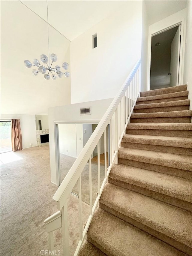 640 S Lake Ave Unit 306, Pasadena, CA 91106 - stairway with carpet flooring, a chandelier, a high ceiling, and a fireplace