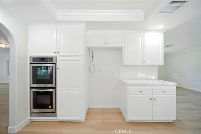 734 Puma Canyon Ln, Glendora, CA 91740 - kitchen with stainless steel double oven, light wood finished floors, ornamental molding, white cabinetry, and a tray ceiling