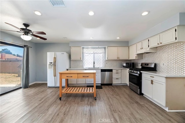 2294 Daisy Way, Hemet, CA 92545 - kitchen featuring stainless steel appliances, under cabinet range hood, light countertops, tasteful backsplash, and light wood-style floors