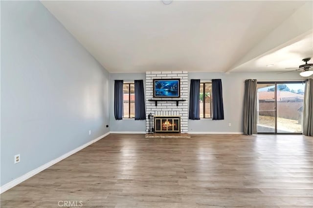 2294 Daisy Way, Hemet, CA 92545 - unfurnished living room featuring lofted ceiling, a brick fireplace, wood finished floors, and ceiling fan