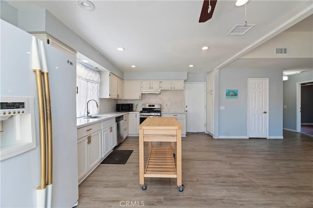 2294 Daisy Way, Hemet, CA 92545 - kitchen featuring appliances with stainless steel finishes, backsplash, light wood-style flooring, light countertops, and recessed lighting