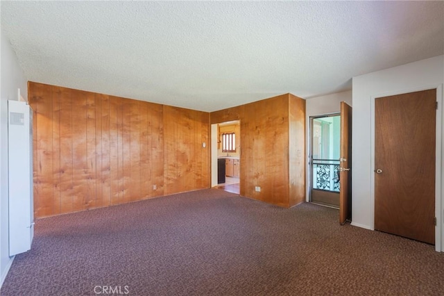 2001 W Jan Way, Santa Ana, CA 92704 - unfurnished bedroom featuring carpet, wood walls, and a textured ceiling