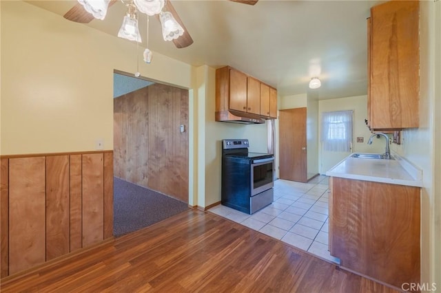 2001 W Jan Way, Santa Ana, CA 92704 - kitchen with stainless steel electric range, a ceiling fan, under cabinet range hood, light countertops, and light wood finished floors