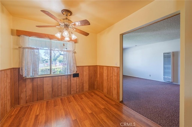 2001 W Jan Way, Santa Ana, CA 92704 - unfurnished room with a heating unit, a wainscoted wall, a ceiling fan, wood finished floors, and wooden walls