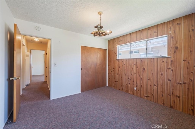 2001 W Jan Way, Santa Ana, CA 92704 - unfurnished bedroom featuring carpet, a chandelier, wood walls, a textured ceiling, and a closet